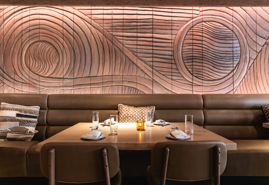 A fully upholstered Brooke chair in a driftwood finish at Lyra restaurant in Chicago.